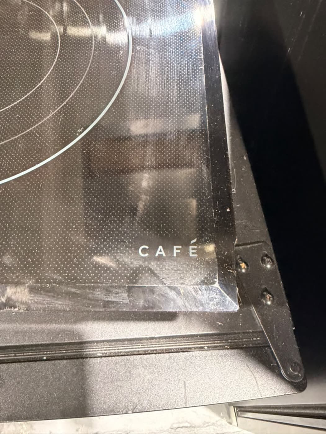 Actual café 36-inch electric cooktop photographed in Oakland Park — seller-disclosed edge/corner crack or chip · detail