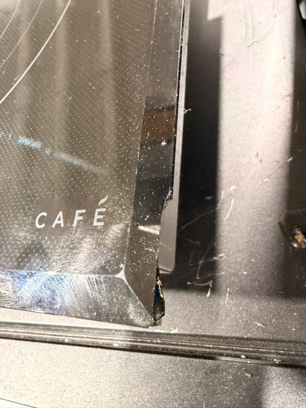 Actual café 36-inch electric cooktop photographed in Oakland Park — seller-disclosed edge/corner crack or chip · close view