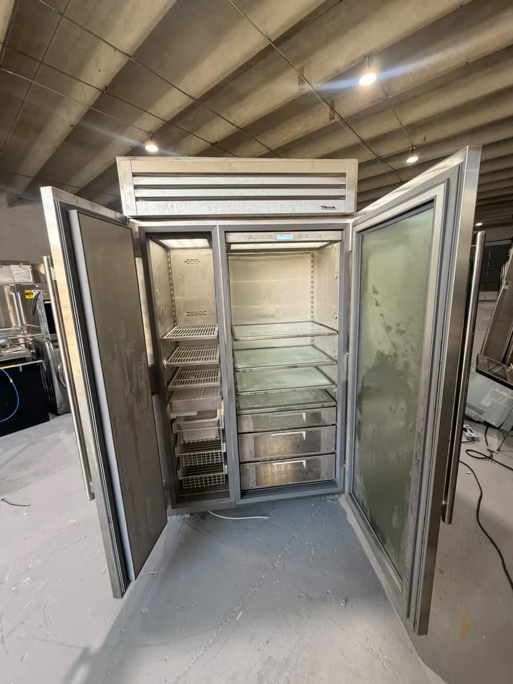 Actual true residential 48-inch refrigerator photographed in Oakland Park — actual unit with both compartments open for interior review.
