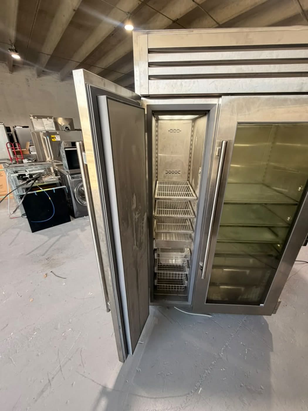 Actual true residential 48-inch refrigerator photographed in Oakland Park — freezer interior showing visible surface marks and the condition of the actual unit.