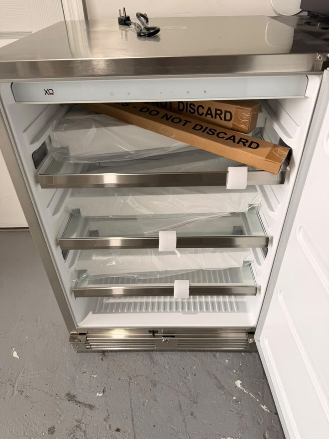 Actual xo 24-inch outdoor refrigerator photographed in Oakland Park — actual unit · shelves and packed accessories