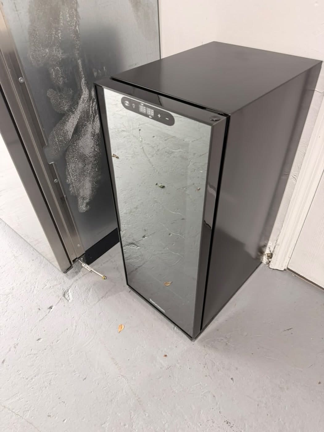 Actual wine enthusiast 18-bottle dual zone wine cooler photographed in Oakland Park — actual unit · closed side angle