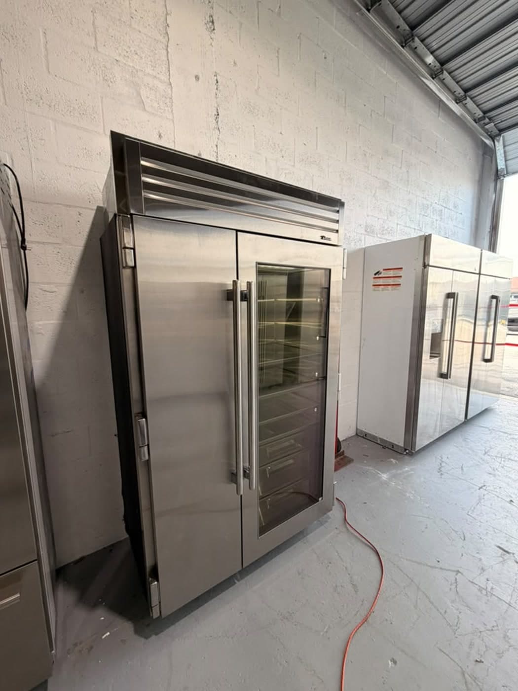 Actual true residential 48-inch refrigerator with glass door photographed in Oakland Park — actual unit · closed side angle